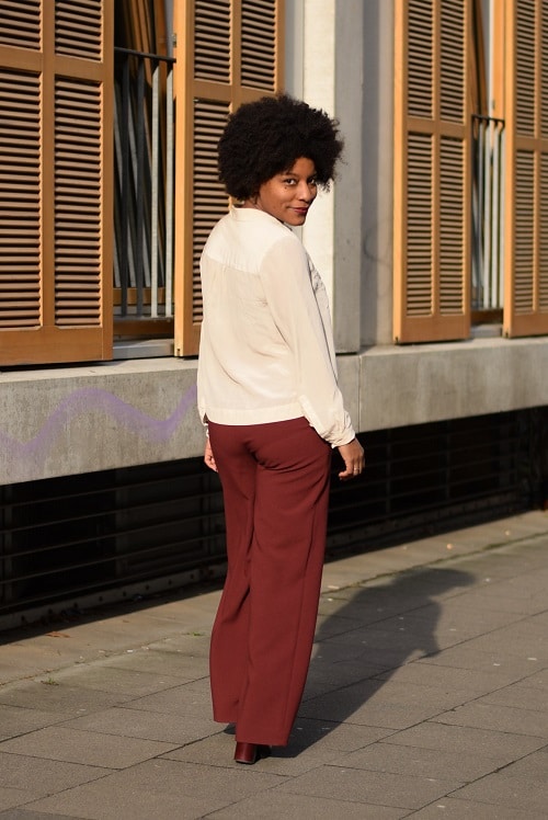 pantalon lage rouge chemisier en soie bege de dos